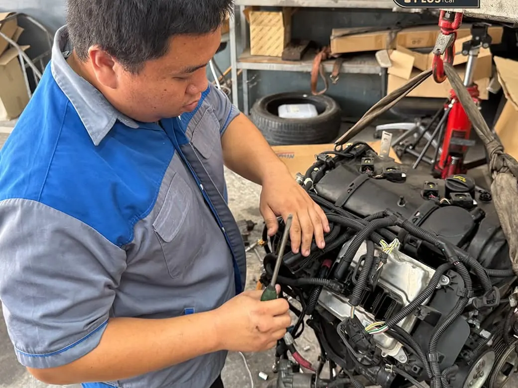 ช่างของ P-Plus BM Service กำลังถอดประกอบเครื่องยนต์ BMW ที่ยกลงมาวางบนพื้น